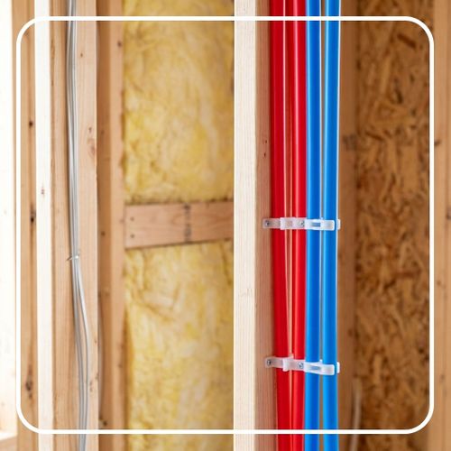 Red and blue PEX tubing secured to a wall stud during installation