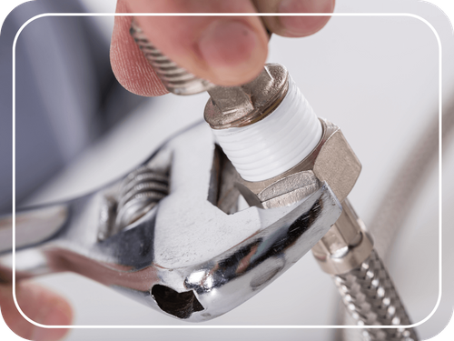 closeup of plumber working with wrench and pipe