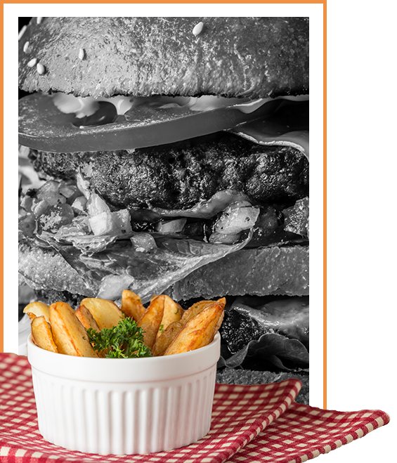 Image of seasoned fries with a burger in the background