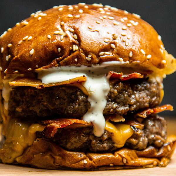 Close-up of a double cheeseburger with bacon and sauce