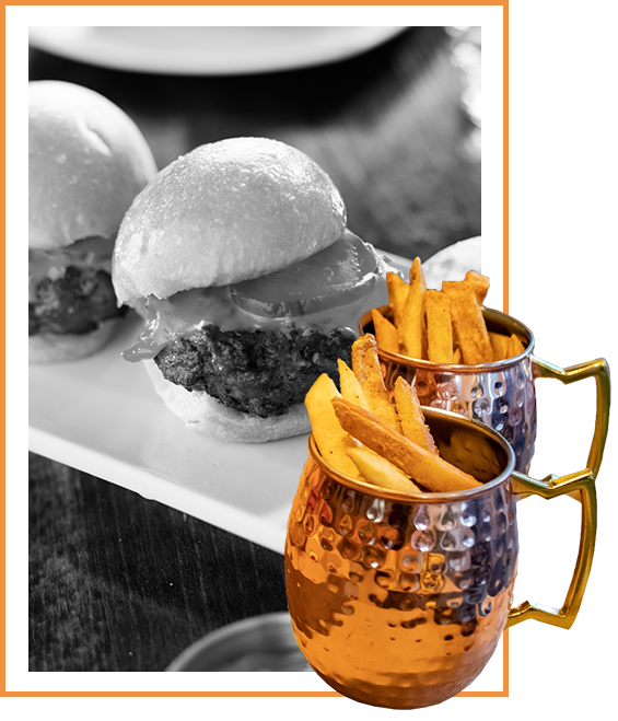 Image of seasoned fries in metal cups with burgers in the background