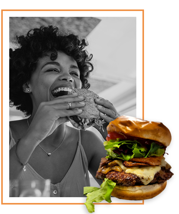 woman smiling and eating a burger