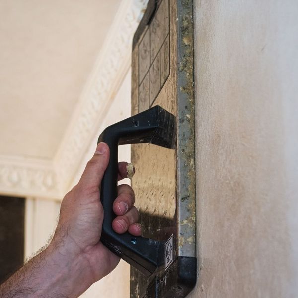 Commercial-grade steam plate applied to old wallpaper, demonstrating the gentle steaming technique for removal.