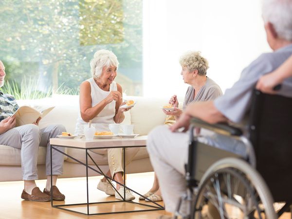 An image of elderly people sitting around a table eating.