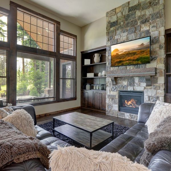 nice room with leather couches, mounted TV, and fireplace