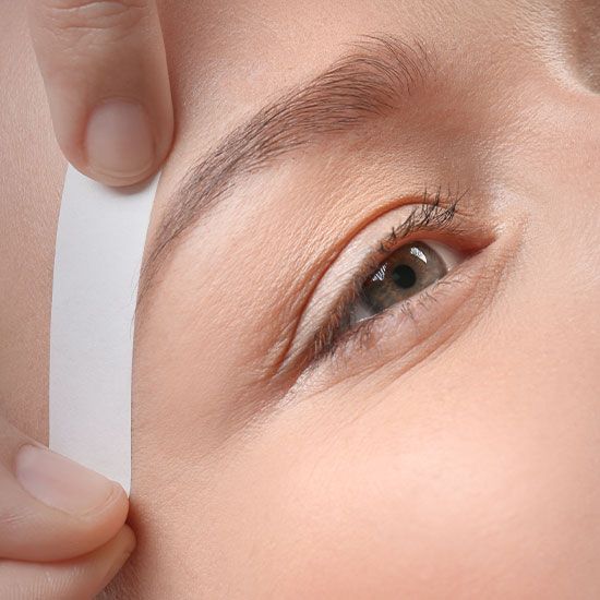 Closeup photo of a woman getting her eyebrow waxed