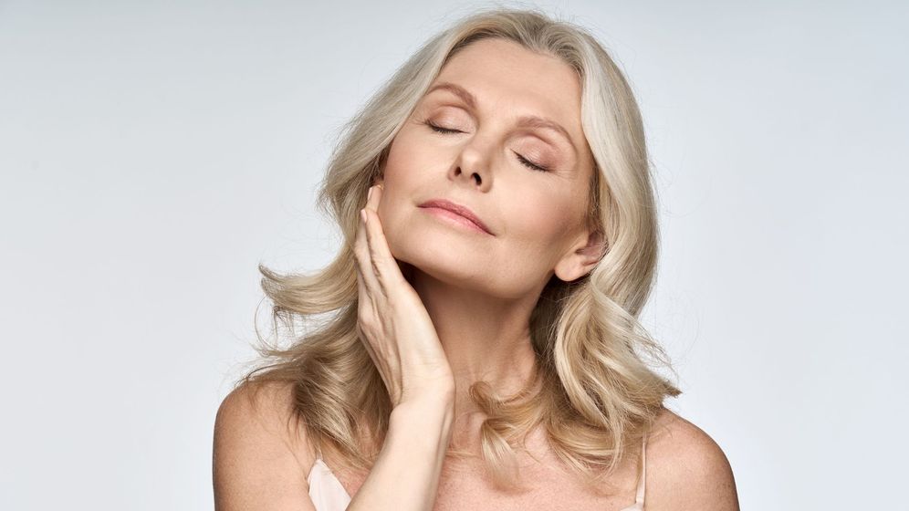 Woman with beautiful skin putting her hand up to her chin. 