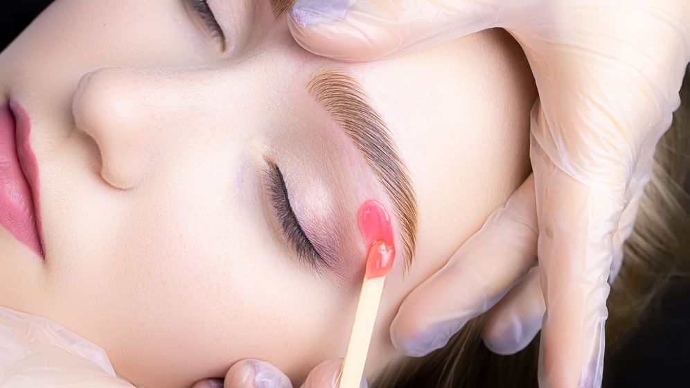woman gets her eyebrows waxed