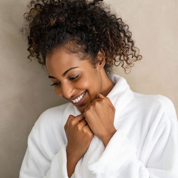 Smiling woman in a white spa robe