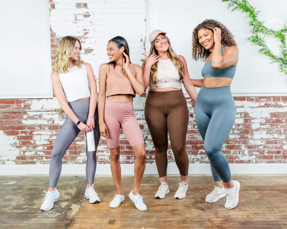 Group of people wearing workout attire smiling together