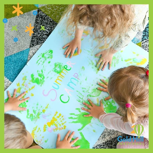 children finger-painting "summer camp" sign