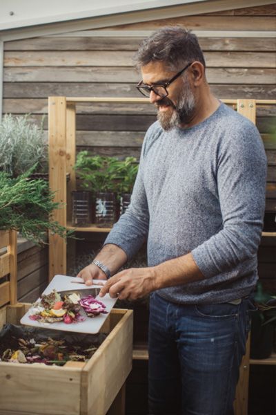 A man composting his leftovers from dinner