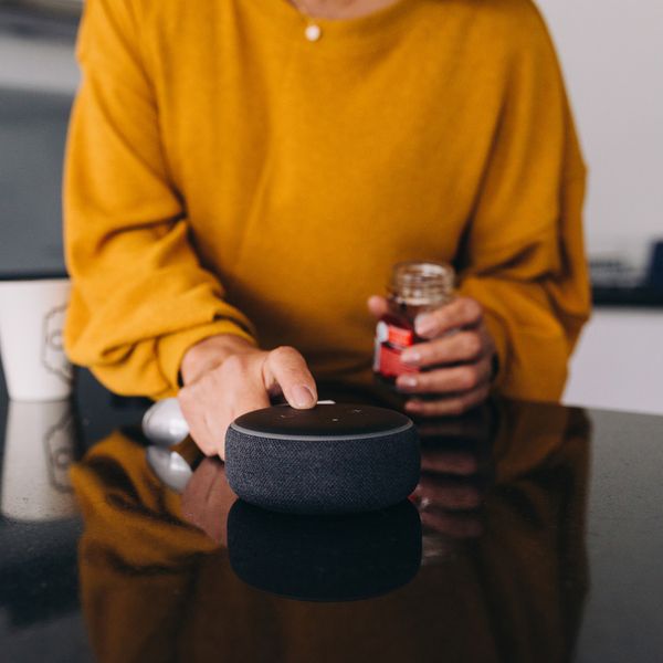 A person in their kitchen using their bluetooth speaker