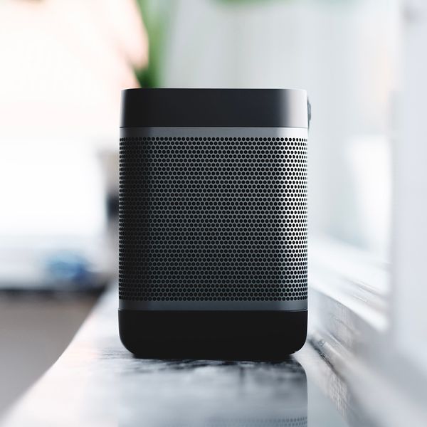 A home speaker on a counter by a window