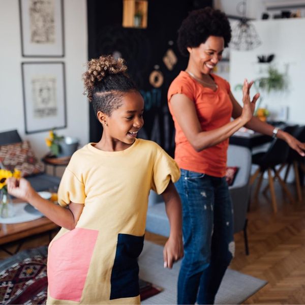 Mother and daughter dancing in their living room