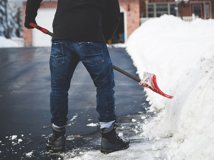 Man shoveling snow from driveway