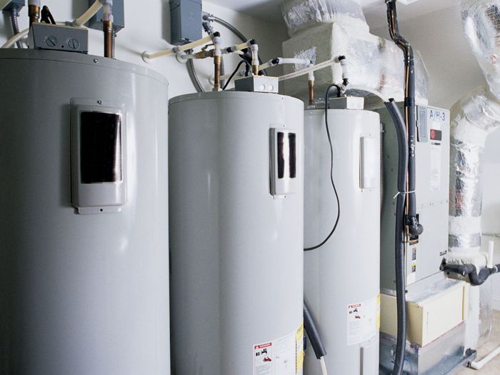 Three water heaters installed next to furnace