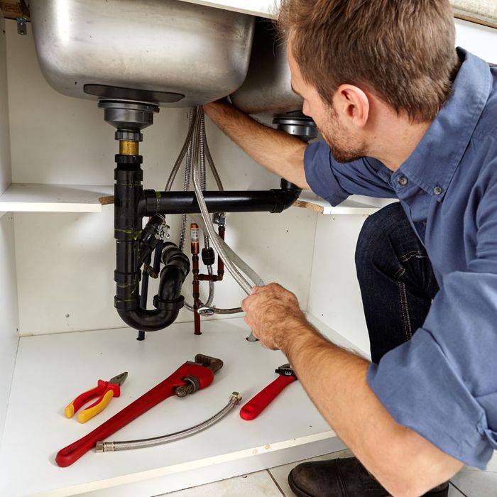 Plumber fixing a kitchen sink