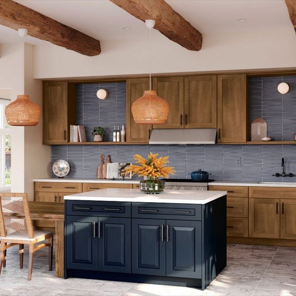 A kitchen with two-toned cabinets, a blue kitchen island, and a dining table and chairs with woven accents. A kitchen with two-toned cabinets, a blue kitchen island, and a dining table and chairs with woven accents.