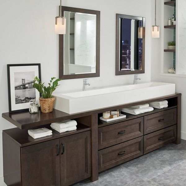 A contemporary bathroom with a dark wood double vanity, a long white sink, and two rectangular mirrors with pendant lights. A contemporary bathroom with a dark wood double vanity, a long white sink, and two rectangular mirrors with pendant lights.