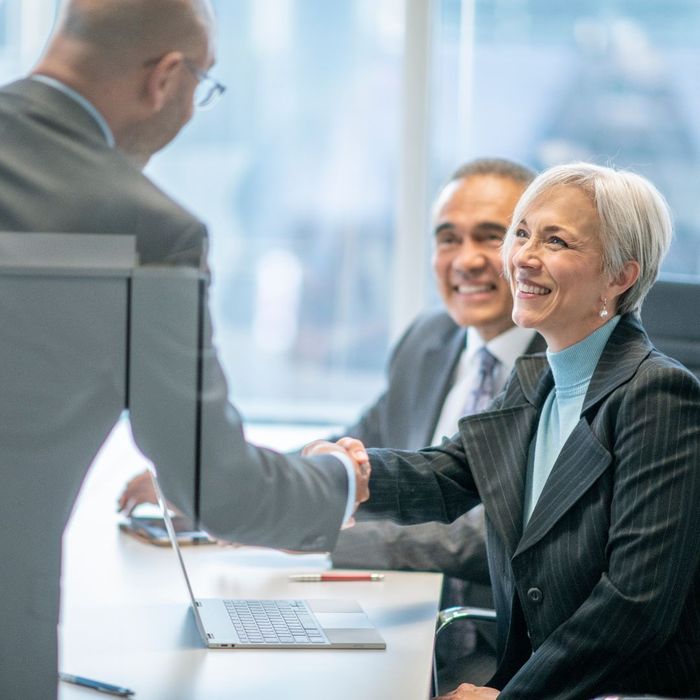 Business executives shaking hands in a meeting room