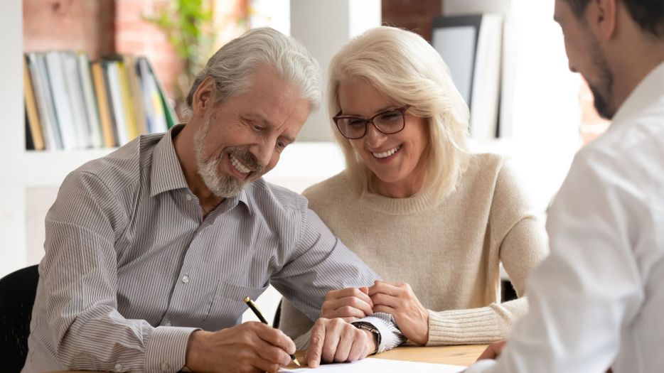 Mature couple signing business documents