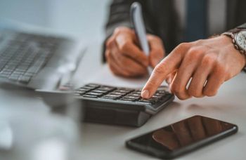 person using calculator at desk