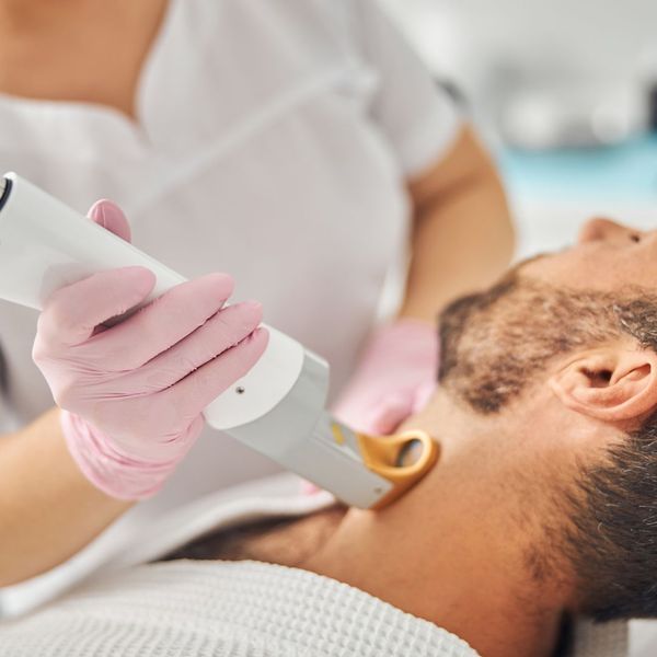 Man receiving hair removal treatment on neck