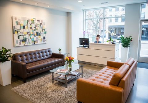 A bright, clean, and modern salon reception area featuring leather couches and large windows 1768422702163/sample_0.jpg