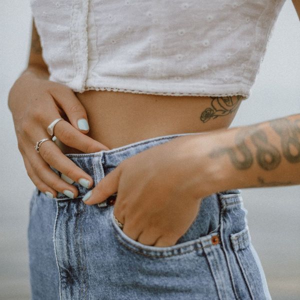 woman with tattoos on arm and ribcage
