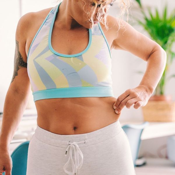 woman pinching skin on stomach