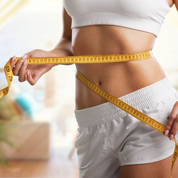 measuring tape on waist: weight loss