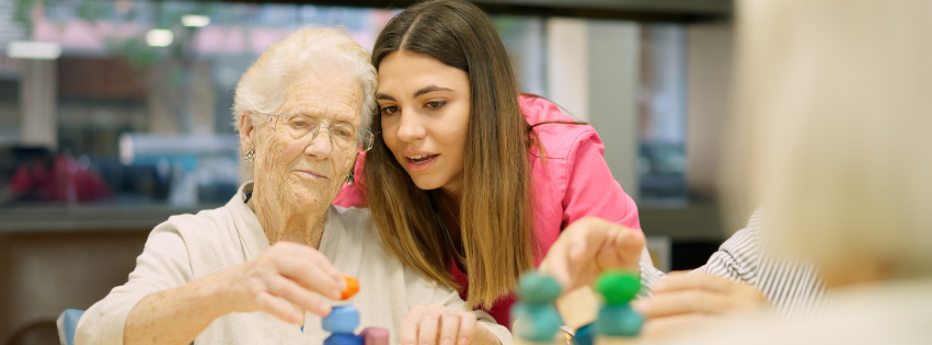 Young woman doing a puzzle with an old woman