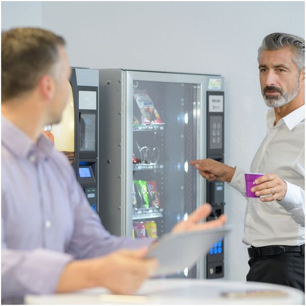 employees talking in break room by vending machine