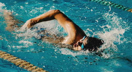 person in a pool swimming laps. 