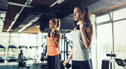 two women lifting weights. 