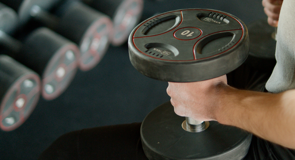 person resting dumbbells on their thighs. 