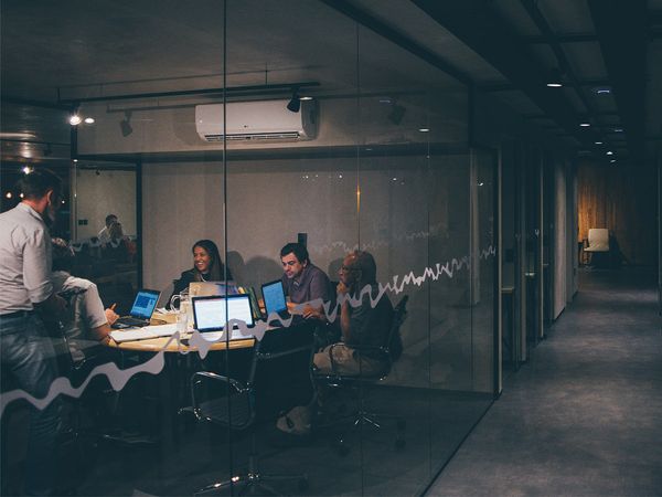 A group of people working in an office space at night.