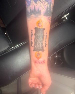 A tattoo of a candle lit