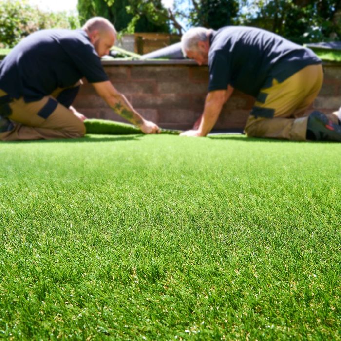 Two men installing fake grass