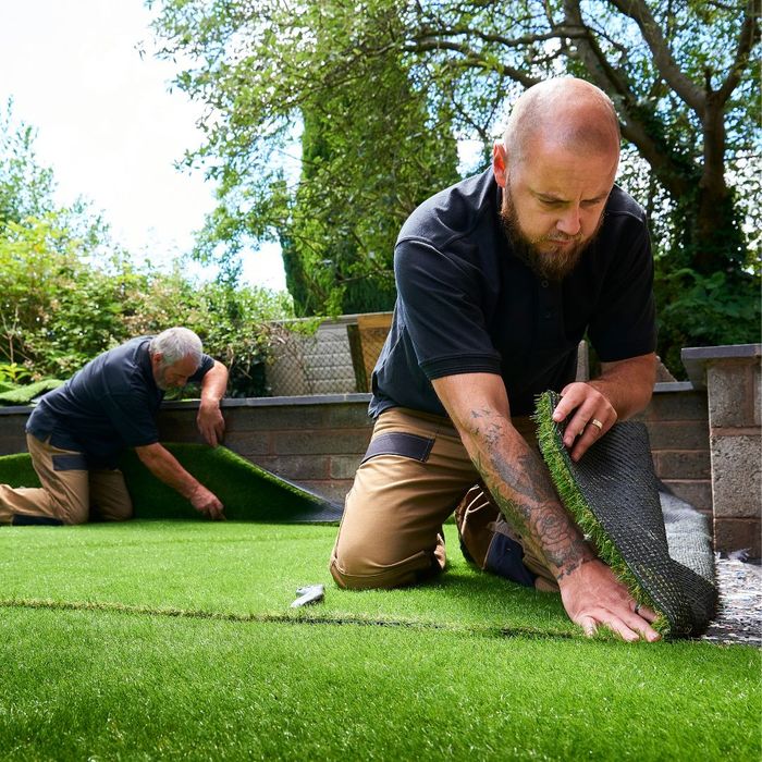 Two men installing artificial turf