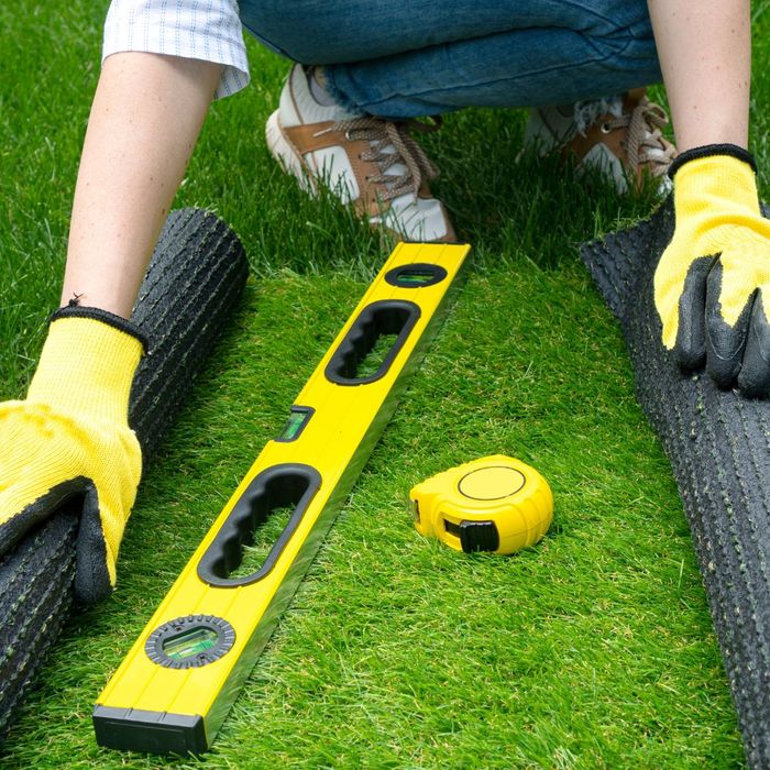 Landscaper with tools for installing fake grass