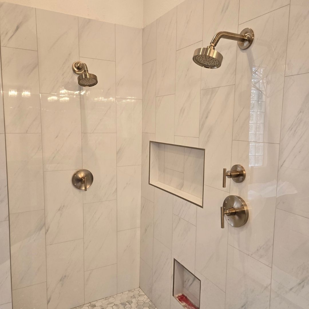 Tiled walk-in shower with dual showerheads and brushed metal fixtures