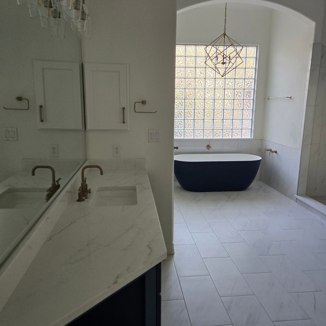 Modern bathroom with long double vanity and freestanding black bathtub in background