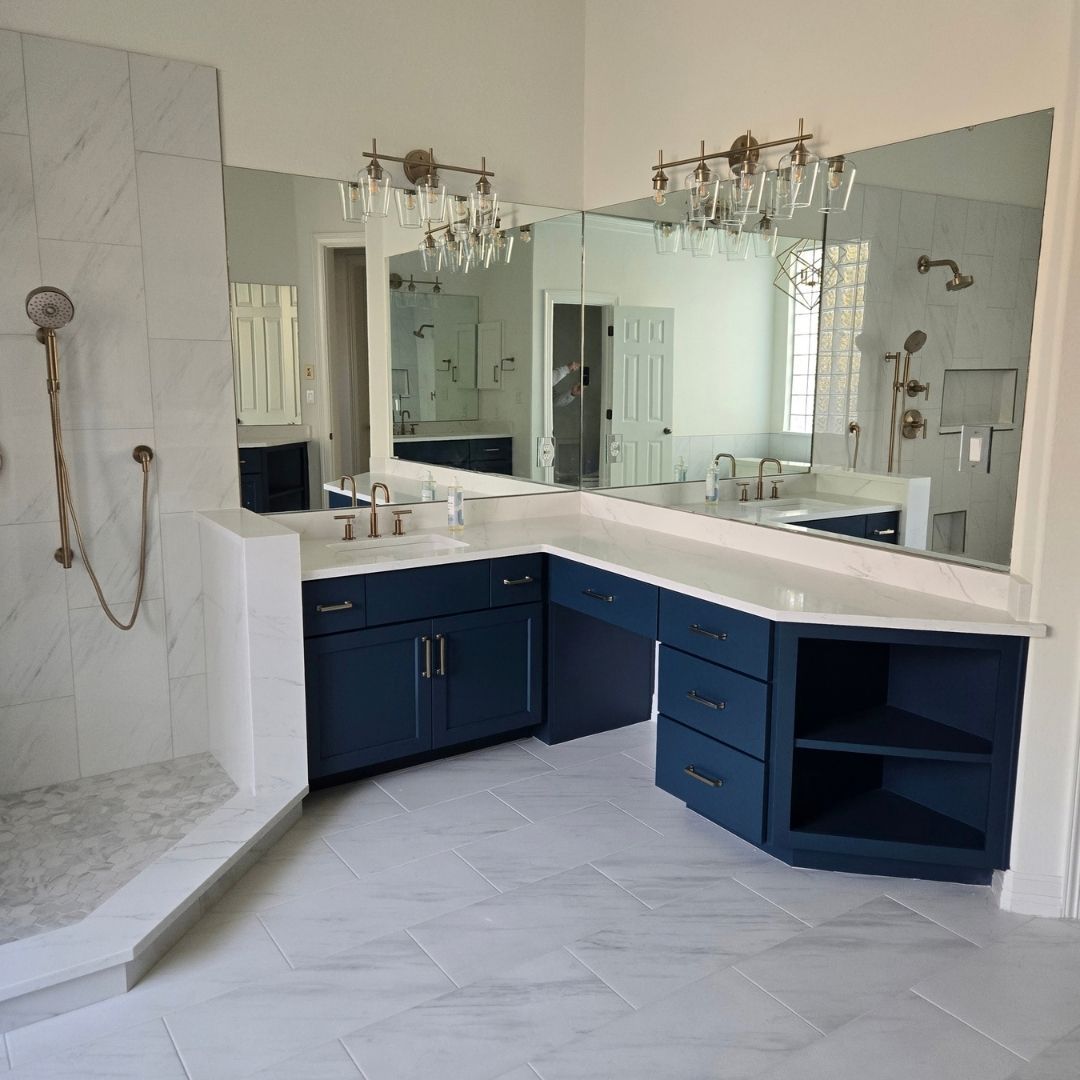 Spacious bathroom featuring dark blue vanity cabinets and tile flooring