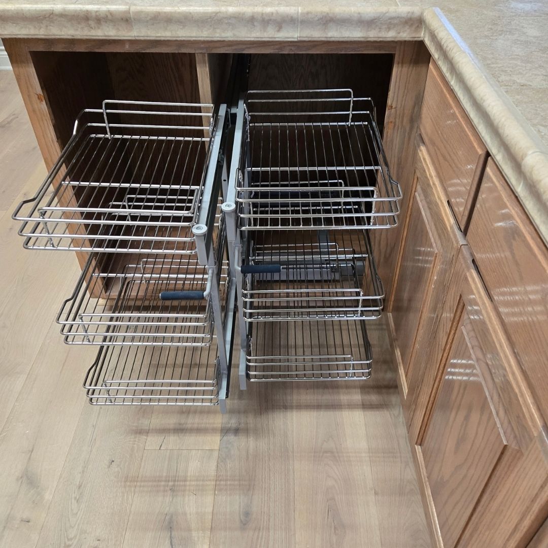 Pull-out metal wire organizer inside a corner kitchen cabinet   