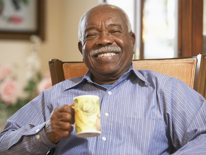 smiling older Black man with coffee mug