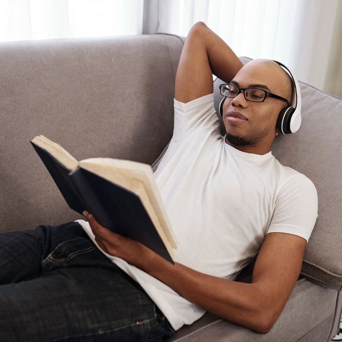 a man listening to headphones and reading a book