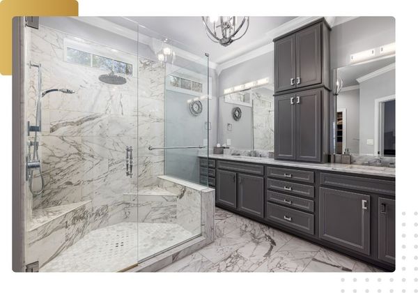 High-end bathroom remodel with marble tile shower, built-in seat, and gray vanity cabinets (focus is on the shower wet space).