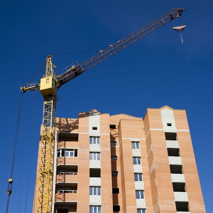construction crane lifting over the top of a building